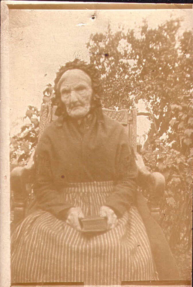 Vannskadet bilde av en gammel dame før restaurering.